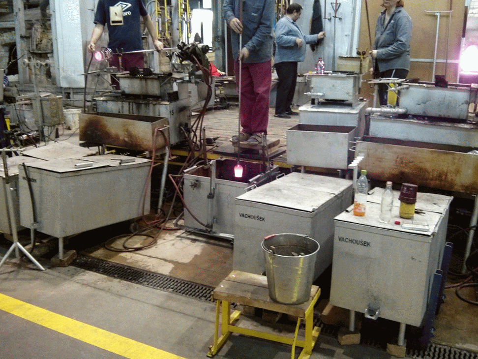 Apprentice putting the hot glass into the mold